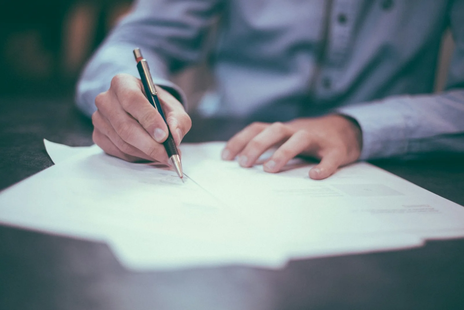 Person completing a questionnaire on paper, suggesting self-report assessment