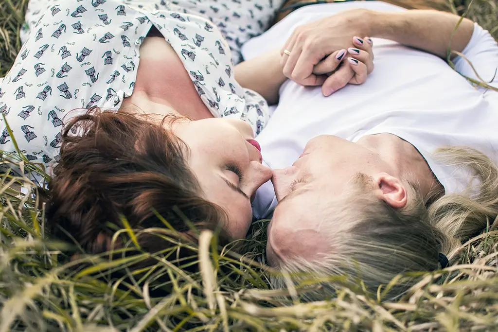 Couple laying peacefully on grass, symbolizing secure and harmonious relationships - representing emotional security and attachment